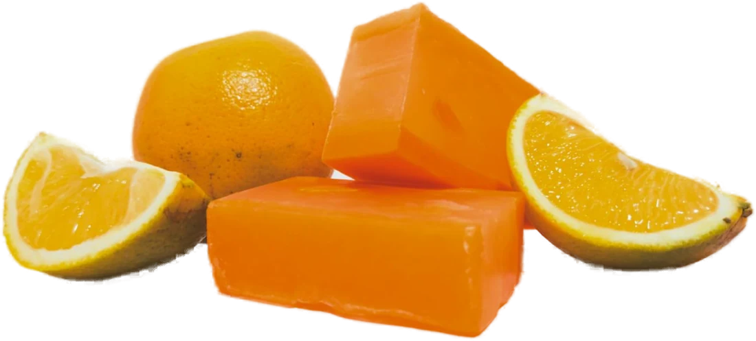 Barras de jabón de naranja junto a naranjas cortadas